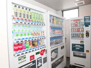 福岛Hotel Route Inn Fukushima Nishi Inter的商店里装有饮料的两台汽水机