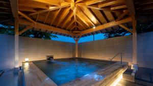 北塩原村EN RESORT Grandeco Hotel的一个带木屋顶的大型游泳池