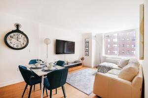纽约Lovely 2 Bedroom Apartment的带沙发、桌子和时钟的客厅