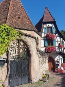 凯泽贝尔la Parenthèse Kaysersberg的一座带门的建筑和一座鲜花盛开的房子