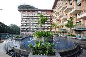 班加罗尔ITC Gardenia, a Luxury Collection Hotel, Bengaluru的建筑前的一座带游泳池的建筑