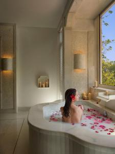 班加罗尔ITC Gardenia, a Luxury Collection Hotel, Bengaluru的坐在浴室浴缸里的女人