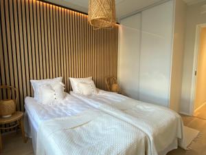 拉赫蒂Upea saunallinen kaksio Sibeliustalon vieressä的一间卧室配有一张带白色床单的大床