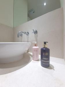 伦敦Ravishing Riverside 2-Bed Rental in Canary Wharf的浴室提供2瓶肥皂和水槽。