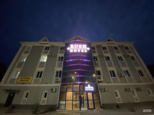 阿特劳Rush Hotel的上面有紫色灯的建筑
