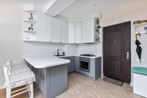 巴库里阿尼HCG Panorama Villa Deluxe Apartment的厨房配有白色橱柜、水槽和门