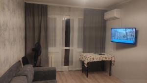 切尔尼戈夫Apartment near city center on Peremohy Avenue 46的客厅配有桌子,墙上配有电视