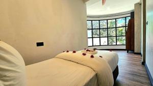 迪古拉Dhigurah Cottage的一间卧室,床上有红色的鲜花