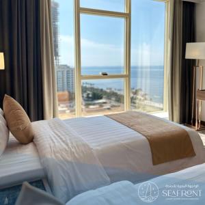 吉达Seafront Luxury Suites Jeddah Corniche的一间卧室设有一张大床和大窗户