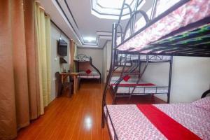 CabanganMommy Linda Beach Resort的客房设有两张双层床和一扇窗户。