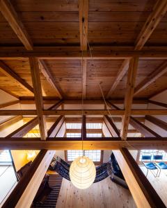 长野Villa Iizuna Plateau -飯綱高原の山荘-的吊灯挂在木天花板的外墙上