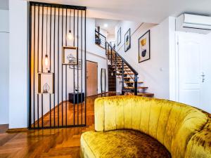 布尔奇科Lofty的客厅设有黄色沙发和楼梯。