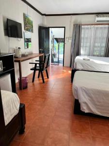 万荣美景旅馆的酒店客房设有两张床、一张桌子和一张桌子。