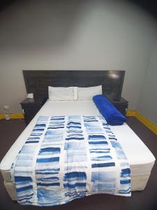 伯诺尼Prime Guest Inn的床上有蓝色和白色的毯子