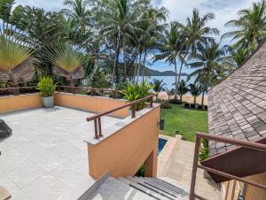 象岛Beachfront 5-bedroom Villa的阳台享有大海和棕榈树的景致。