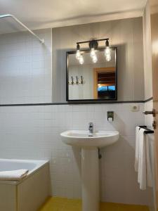 圣地亚哥－德孔波斯特拉Apartamentos Ciudad Santiago的浴室配有盥洗盆、镜子和浴缸