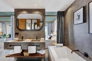 帕尔马海滩Aubamar Suites & Spa的一间带浴缸和大镜子的浴室