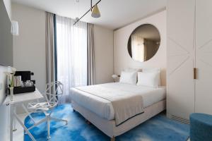 巴黎阿斯托利亚阿斯特拉奥佩拉酒店的一间卧室配有一张床、一张书桌和一面镜子