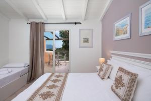 阿兰奇湾城VOI Colonna Village的一间白色卧室,配有床和阳台