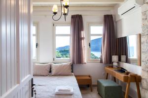 塞沃塔Sivota Villas with Sea Access的客房设有一张床、一张书桌和窗户。