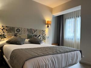 安道尔城图德尔酒店的一间卧室设有一张大床和一个窗户。