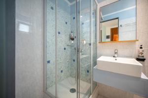 阿基欧斯尼古拉斯Kitro Beach Hotel - Adults Only的一间带水槽和玻璃淋浴的浴室