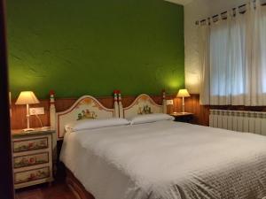 阿雷纳斯德圣佩德罗Casa Rural Crisol Spa的一间卧室配有一张白色的床和绿色的墙壁