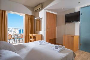 阿基欧斯尼古拉斯Kitro Beach Hotel - Adults Only的酒店客房设有一张床和一个阳台。