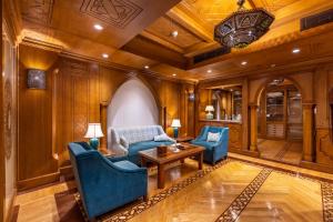 开罗Helnan Landmark Hotel的客厅配有蓝色的椅子和桌子
