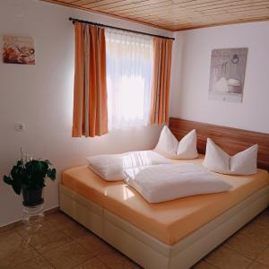 格绍艾格芭芭拉公寓酒店的窗户客房内的一张带白色枕头的床