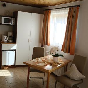 格绍艾格芭芭拉公寓酒店的厨房配有木桌、椅子和窗户