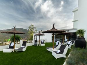 伊斯坦Hotel Altos de Istán的草坪上的一组椅子和遮阳伞