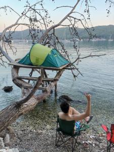 DağpınarSu camping的坐在海滩上靠水的人