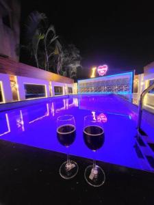 罗纳瓦拉THE PERFECT STAYS: CHOUDHARY VILLA的两个酒杯晚上坐在泳池旁