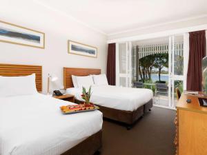 双水域Novotel Sunshine Coast Resort的酒店客房设有两张床和一个阳台。