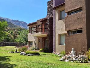 梅洛COSTA COM Departamentos de Montaña的前面有一座绿色庭院的房子