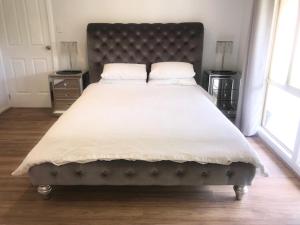 WoodridgeMULBERRY LODGE的卧室配有一张带白色床单和枕头的大床。