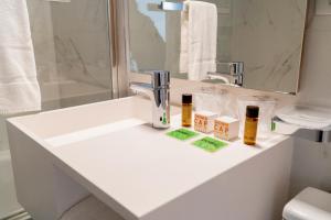 图尔奈阿尔坎塔拉酒店的浴室设有水槽,内有2瓶水