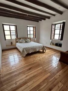 伊瓦拉Casa Campestre en Ibarra的卧室配有一张床、木地板和窗户。