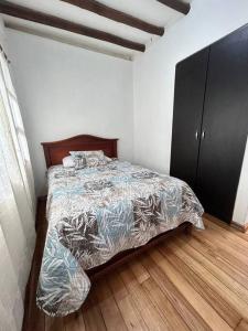 伊瓦拉Casa Campestre en Ibarra的一间卧室配有一张床和一个黑色橱柜