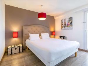 第戎Hôtel Dijon Sud Longvic的一间卧室配有一张带两盏灯的大型白色床。