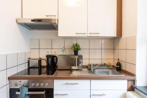 不莱梅Volante Studio Bremen-Findorff的厨房配有白色橱柜和水槽