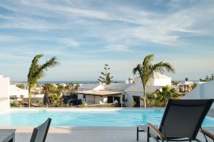 普拉亚布兰卡Villas Altos de Lanzarote的一座棕榈树游泳池和一座房子