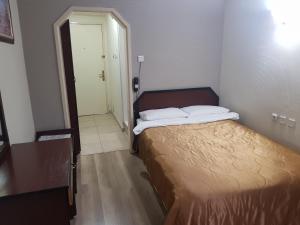 Şahinbeysnowrose hotel的一间小卧室,配有一张床和一个走廊