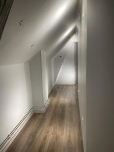 欧塞尔L’escale féerique的空的走廊,有白色的墙壁和木地板