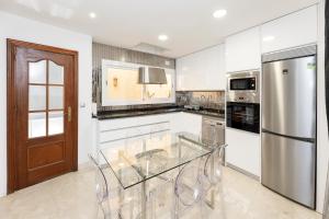 格拉纳达CASA SAN MATIAS的厨房配有玻璃桌和冰箱