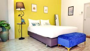 Ban Khuan Raeบ้านเพิงโฮมสเตย์的一间卧室设有一张大床和一张蓝色凳子