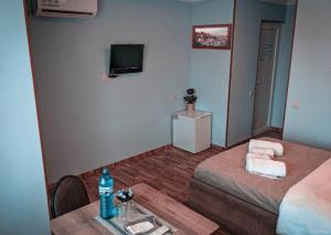 第比利斯Tbilisi Airport Hotel - ATU的客房设有两张床、一张桌子和电视。