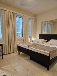 奥卢阿波罗贝斯特韦斯特酒店的卧室的窗户前设有一张大床