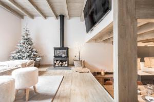贝特伦Casa Baqueira的客厅配有圣诞树和壁炉